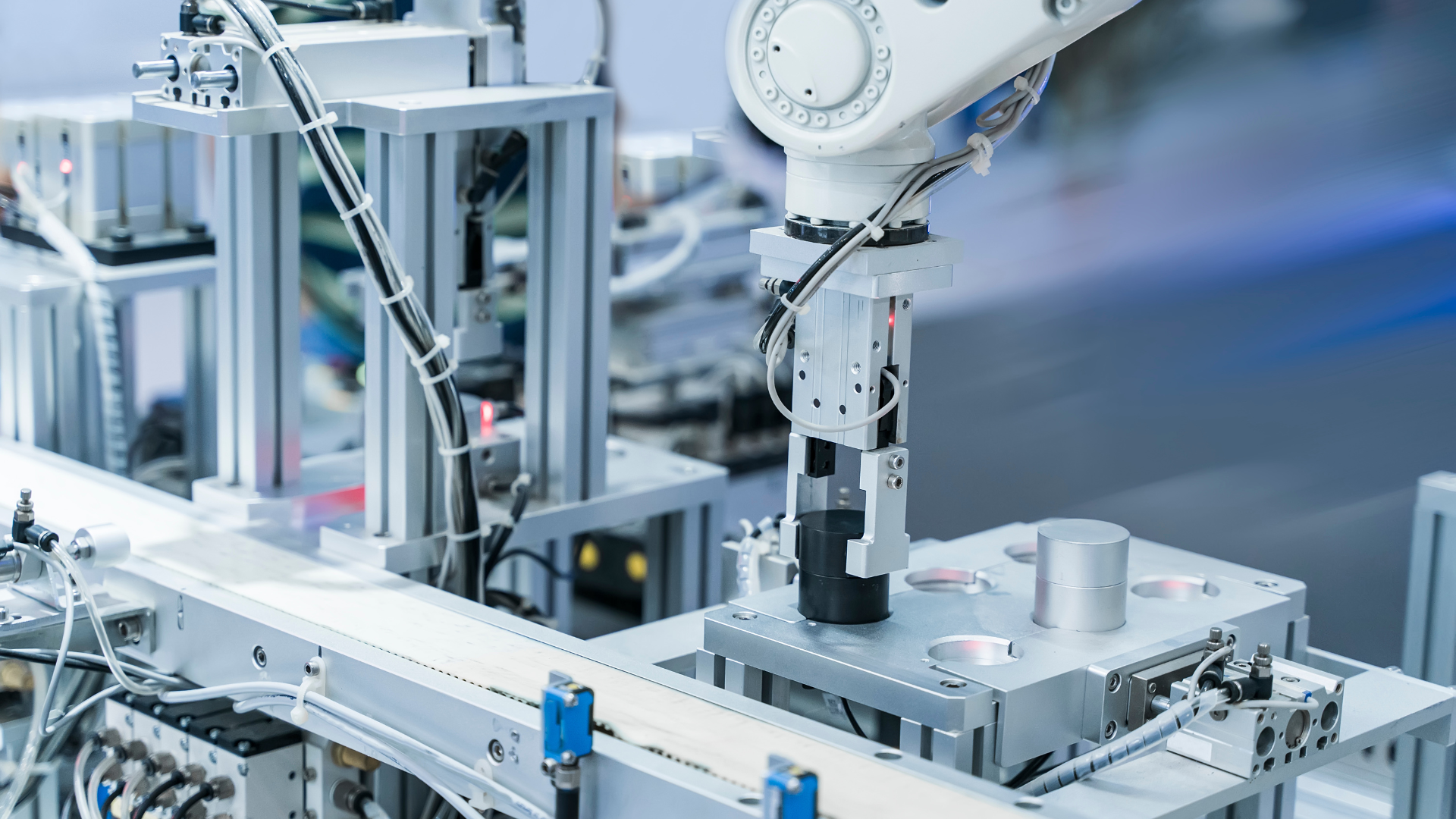 Industrieroboter in einer automatisierten Produktionsanlage mit Fördertechnik und Greifsystem.